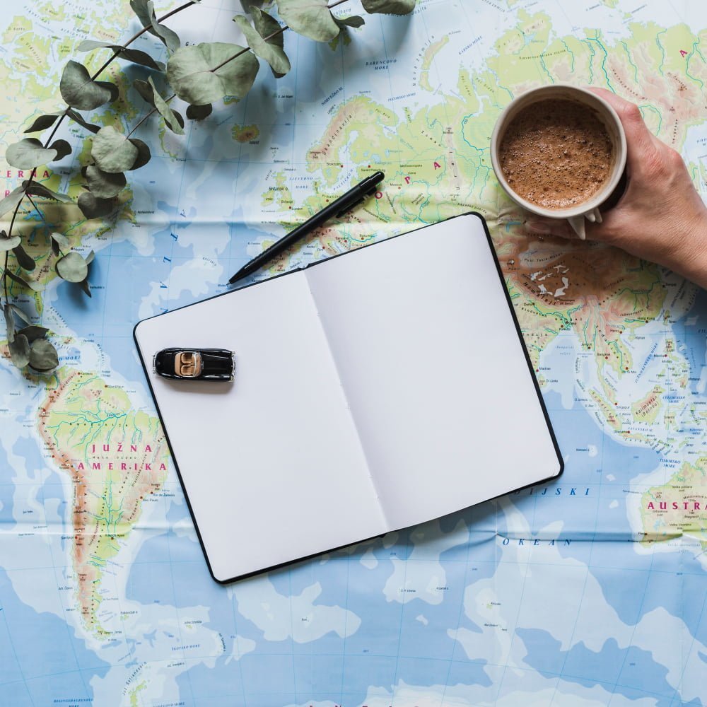 toy-car-blank-diary-hand-holding-coffee-cup-world-map