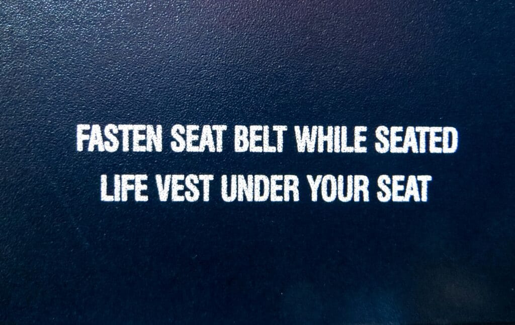 fasten seat belt while seated life vest under your seat
