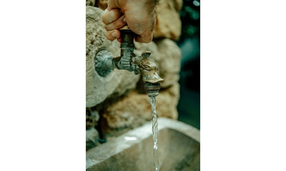 Close up of a person turning on the tap. staying safe with water and ice abroad