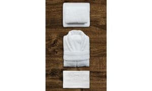 Top view of neatly folded towel and a bathrobe. hotel hygiene hacks in a hotel room