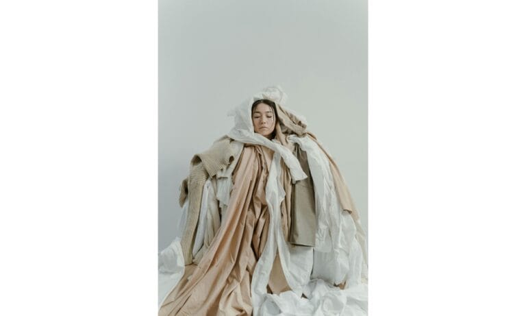 a woman cover with dumped clothes