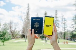 holding passport and smartphone with esim application
