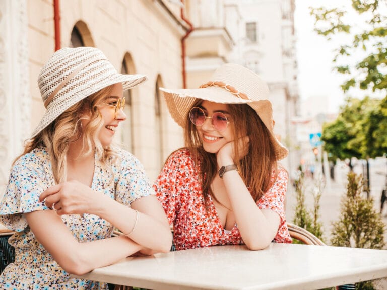 Two young beautiful smiling hipster girls in trendy summer sundress.Carefree