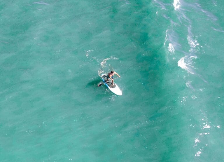 aerial view of solo paddleboarder on turquoise sea