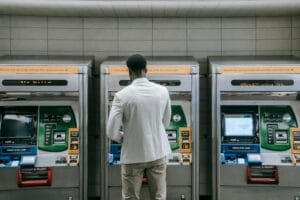 man standing in front of a atm for currency exchange