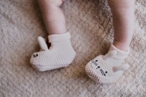 close up photo of knitted footwear of newborn babies