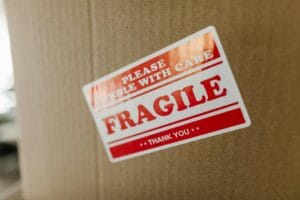 Brown cardboard with a sticker fragile. Mark your bag as fragile with a visible sticker to protect luggage during air travel