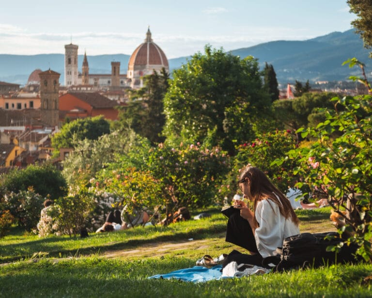 Girl sitting on the grass with a beautiful view of Florence