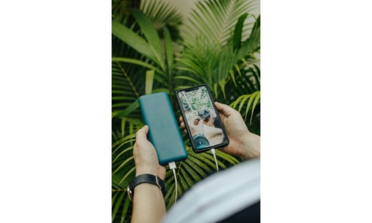 faceless person transferring data from smartphone to hard drive