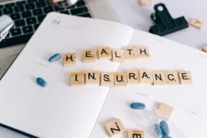 Scrabble Tiles and Blue Pills on a Planner. Learn how to use your bank health insurance cover when travelling abroad.