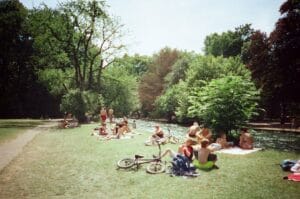 People Relaxing by the River in a Park Setting