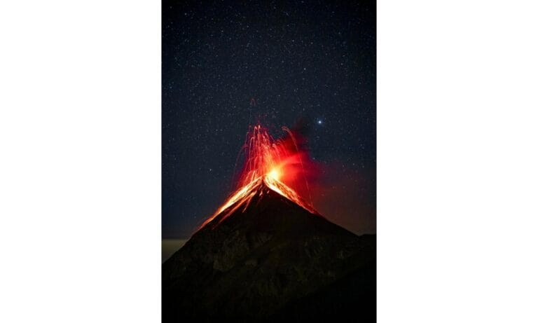 Volcano Erupting at Night Under Starry Sky