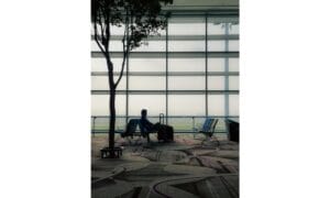 A Man with a Suitcase Sitting Alone at an Airport
