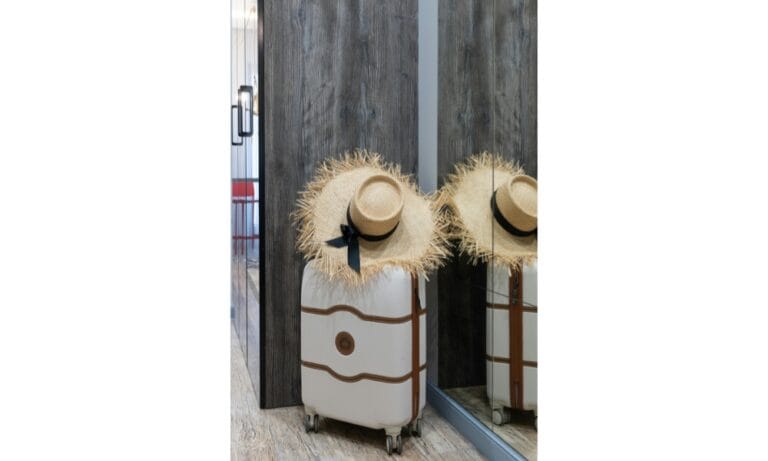 Suitcase with straw hat in corridor