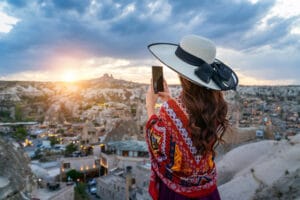Woman take a photo with her smartphone at goreme, cappadocia in turkey.