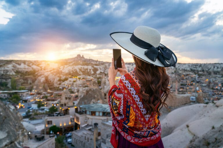 Woman take a photo with her smartphone at goreme, cappadocia in turkey.