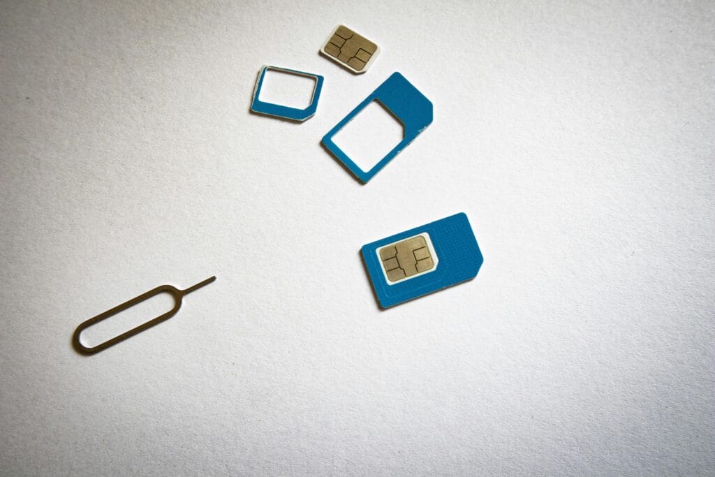 SIM Card and Ejector Tool Flat Lay on White Surface