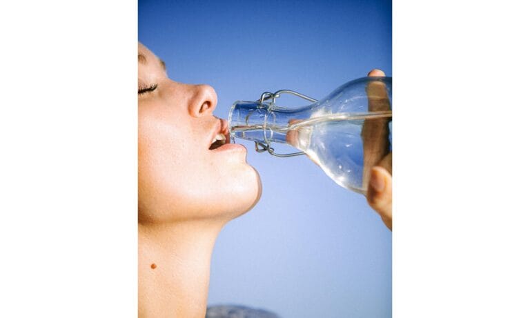 Woman Drinking Water From Glass Bottle