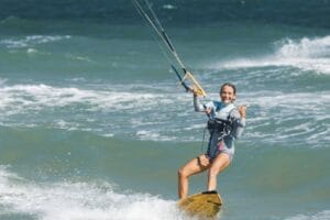 Smiling Woman Kitesurfing and Gesturing