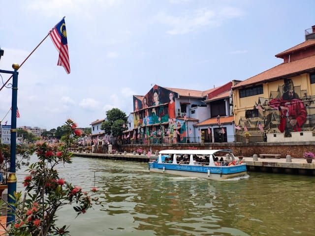 boat with tourists sailing along the street with painted buildings