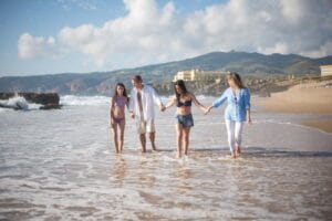 A Family Walking on Seashore Holding Hands