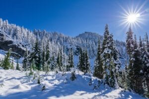 the sun shines brightly over a snowy mountain