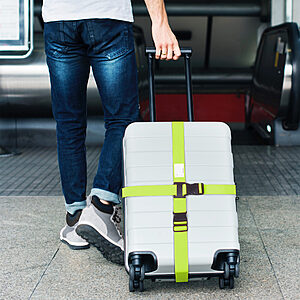 Suitcase secured with bright adjustable luggage straps at an airport baggage carousel making luggage easier for travellers to identify
