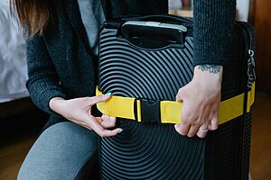 Colourful luggage tags and bright suitcase straps attached to travel bags on an airport baggage carousel