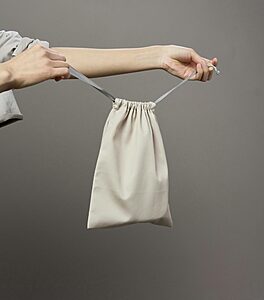 Open suitcase showing neatly packed clothes with shoes stored inside protective shoe bags for travel