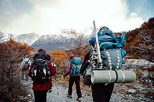 • Hikers wearing backpack with essential hiking accessories on a forest trail