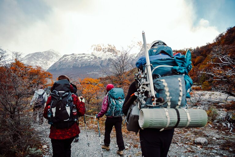 • Hikers wearing backpack with essential hiking accessories on a forest trail