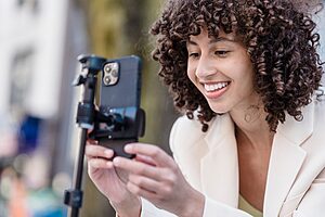 Solo traveller setting up smartphone propped on a mini tripod for self-portrait photography