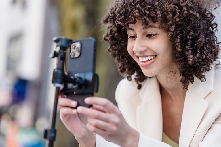 Solo traveller setting up smartphone propped on a mini tripod for self-portrait photography