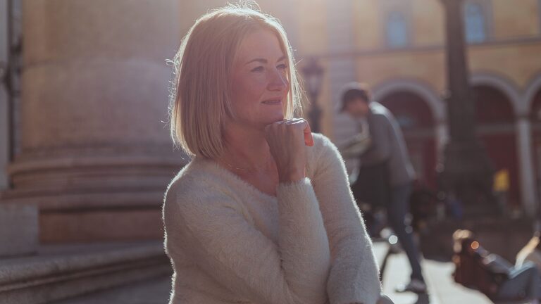 Woman sitting alone looking relaxed and thoughtful