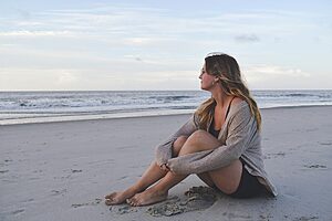 Solo traveller sitting on the beach during a healing holiday after divorce