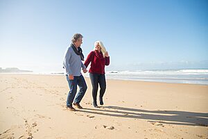 Elderly couple walking along a scenic coastal path on holiday
