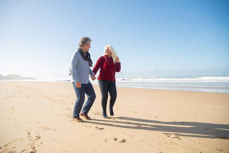 Elderly couple walking along a scenic coastal path on holiday