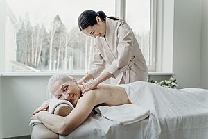 Senior woman receiving a gentle massage treatment at a wellness retreat