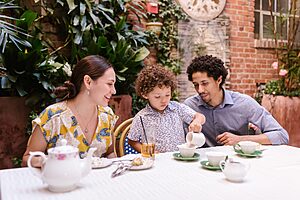 Family having a joyful tea time at an outdoor café.