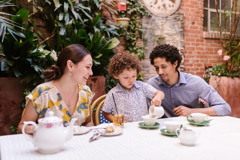 Family having a joyful tea time at an outdoor café.