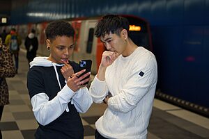 Students checking for a railcard at subway station