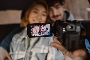 Couple filming travel vlog with compact camera